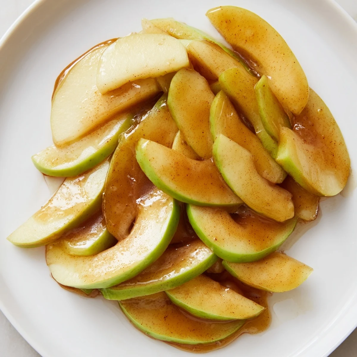 A close-up of tender, flavorful baked apple slices with cinnamon, ready to serve warm.