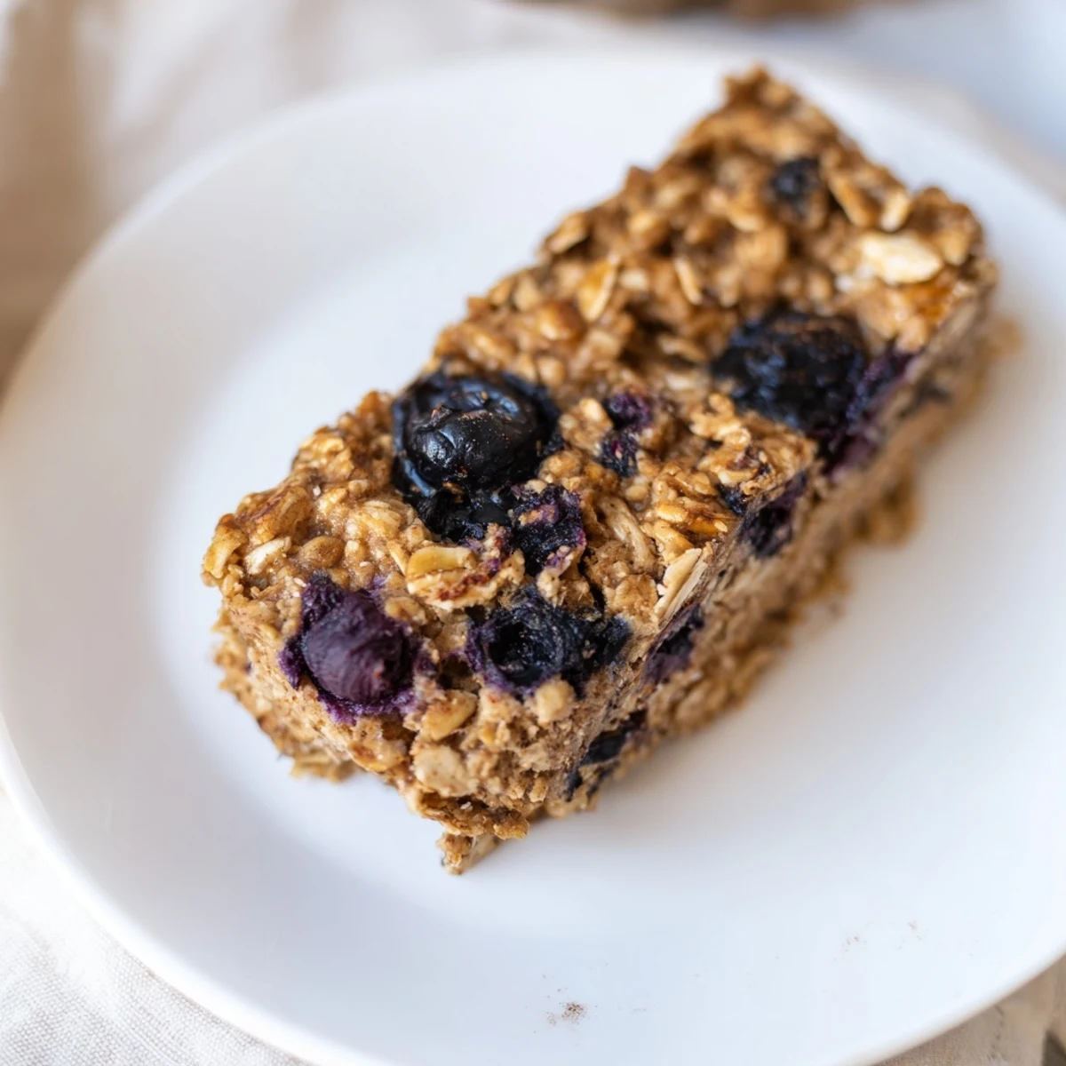 Golden-brown Blueberry Banana Oatmeal Protein Bars with bursts of juicy blueberries; a delicious breakfast recipe.