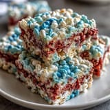 Chewy, colorful 4th of July Rice Krispies Treats stacked in festive red, white, and blue for a holiday dessert.