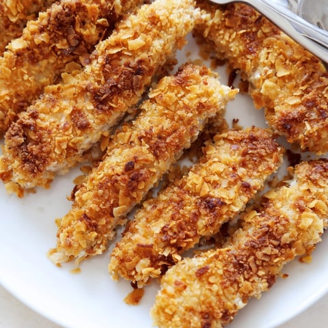 Crispy baked chicken tenders arranged on a sheet pan, golden and ready for dipping sauce.