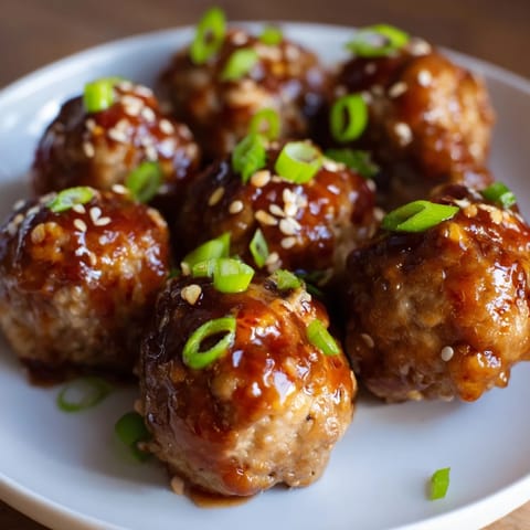 Plump, oven-baked Spicy Sriracha Honey Meatballs, coated in a sticky, vibrant sauce, perfect appetizer.