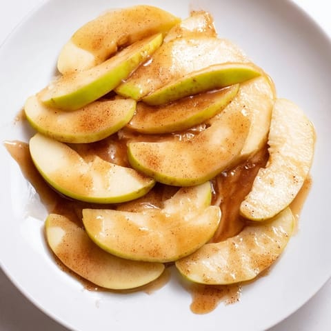 Golden-brown baked apple slices, sweetened with brown sugar and cinnamon, ideal for a sweet treat.