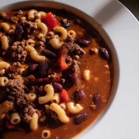 A spoonful of One-Pot Ditalini with Hot Cocoa Chili shows creamy pasta and rich, dark chili.
