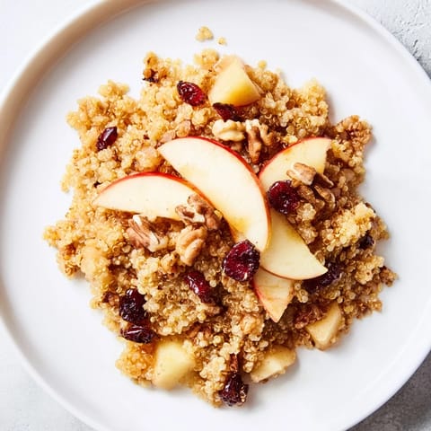 Fluffy Apple Cinnamon Quinoa Bowl, topped with nuts and fruit, a delicious and easy gluten-free breakfast.