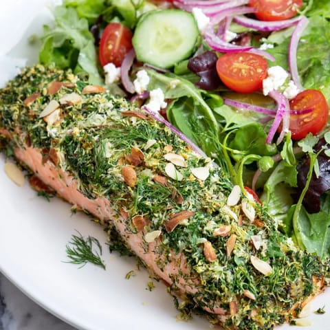 Perfectly cooked herb-crusted salmon nestled among fresh salad greens in this healthy meal.