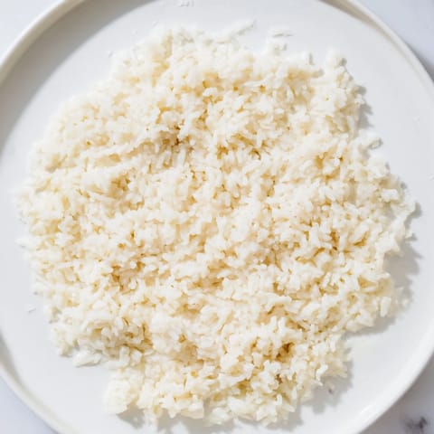 Steaming Coconut Jasmine Rice in a pot, smelling fragrant, with a suggested serving of fresh lime.