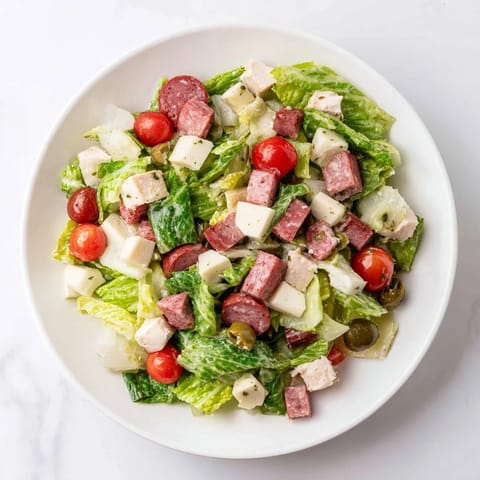 Hearty chopped chicken salad with salami, provolone, cucumbers, and red onion, ready for a quick weeknight meal.  