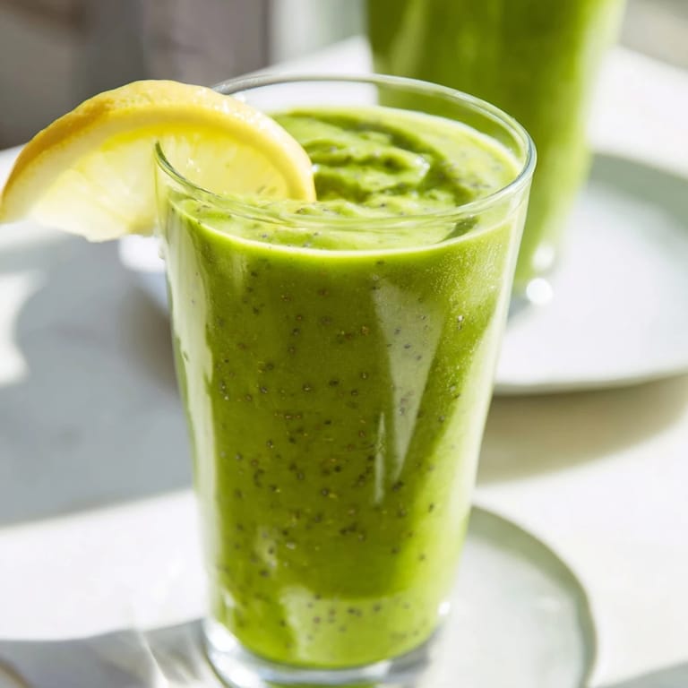 Bright green Spinach Avocado Smoothie, served cold, promises a refreshing, fruity, dairy-free treat.