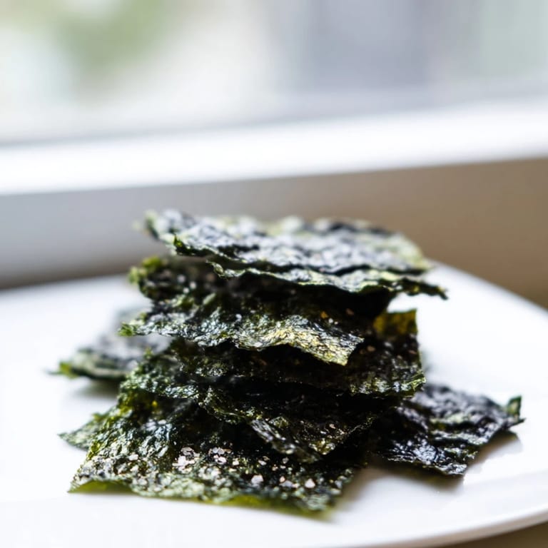 Savory roasted seaweed chips on a baking sheet, crisp and seasoned for snacking.  