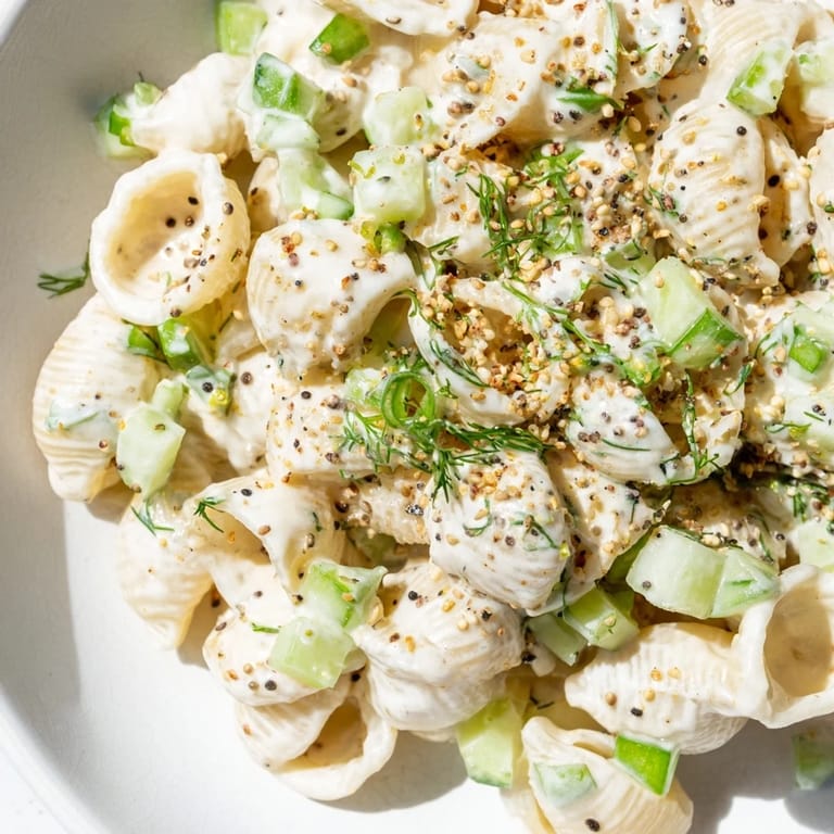 Serving Cucumber Crunch Pasta Salad alongside grilled chicken at a sunny summer picnic table.