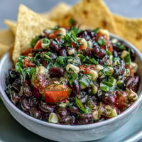 Zesty cowboy caviar dip with black beans, corn, and pico de gallo—ideal for summer parties and snacking.
