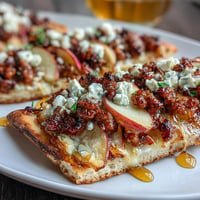 Hot honey apple sausage flatbread with melted cheese and savory toppings.